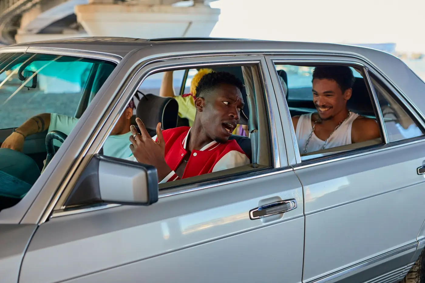 Friends sharing a ride, talking through the open car windows